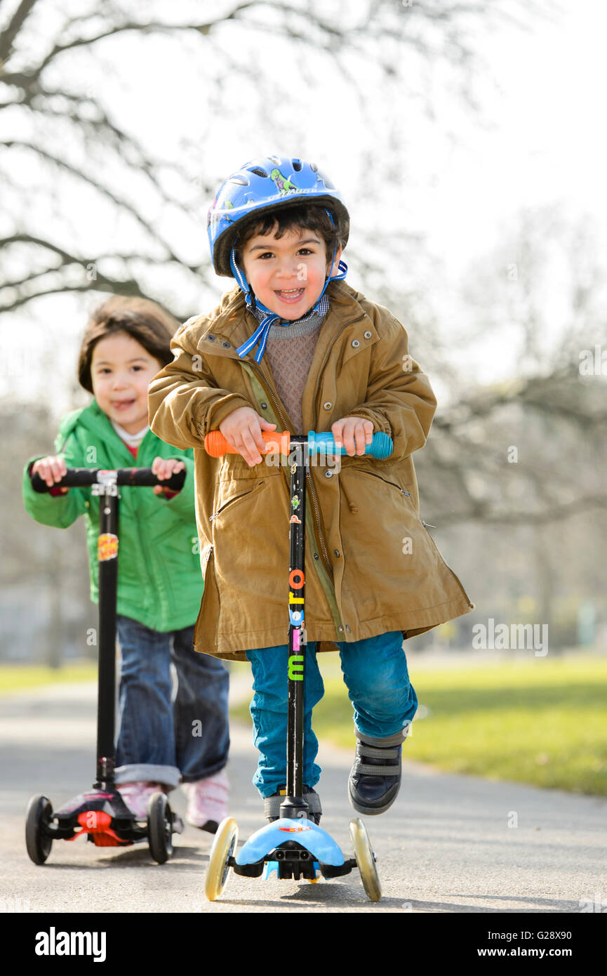 Kids playing with kickboards in a park Stock Photo - Alamy