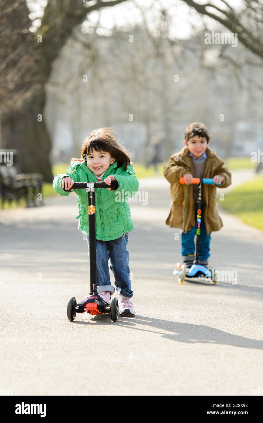 Kids playing with kickboards in a park Stock Photo - Alamy