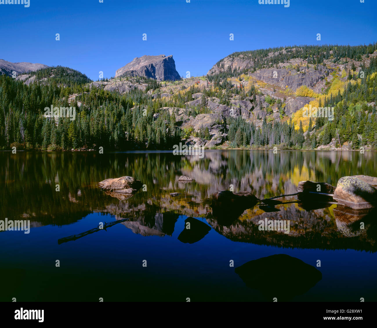 USA, Colorado, Rocky Mountain National Park, Hallett Peak and fall colored slopes reflect in Bear Lake in early morning. Stock Photo