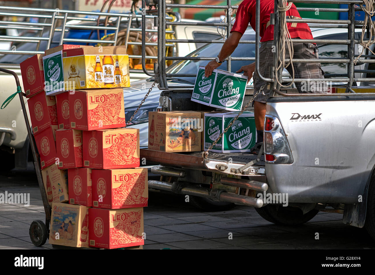 Man loading assorted cases of traditional Thai wines and beer. Thailand S. E. Asia Stock Photo