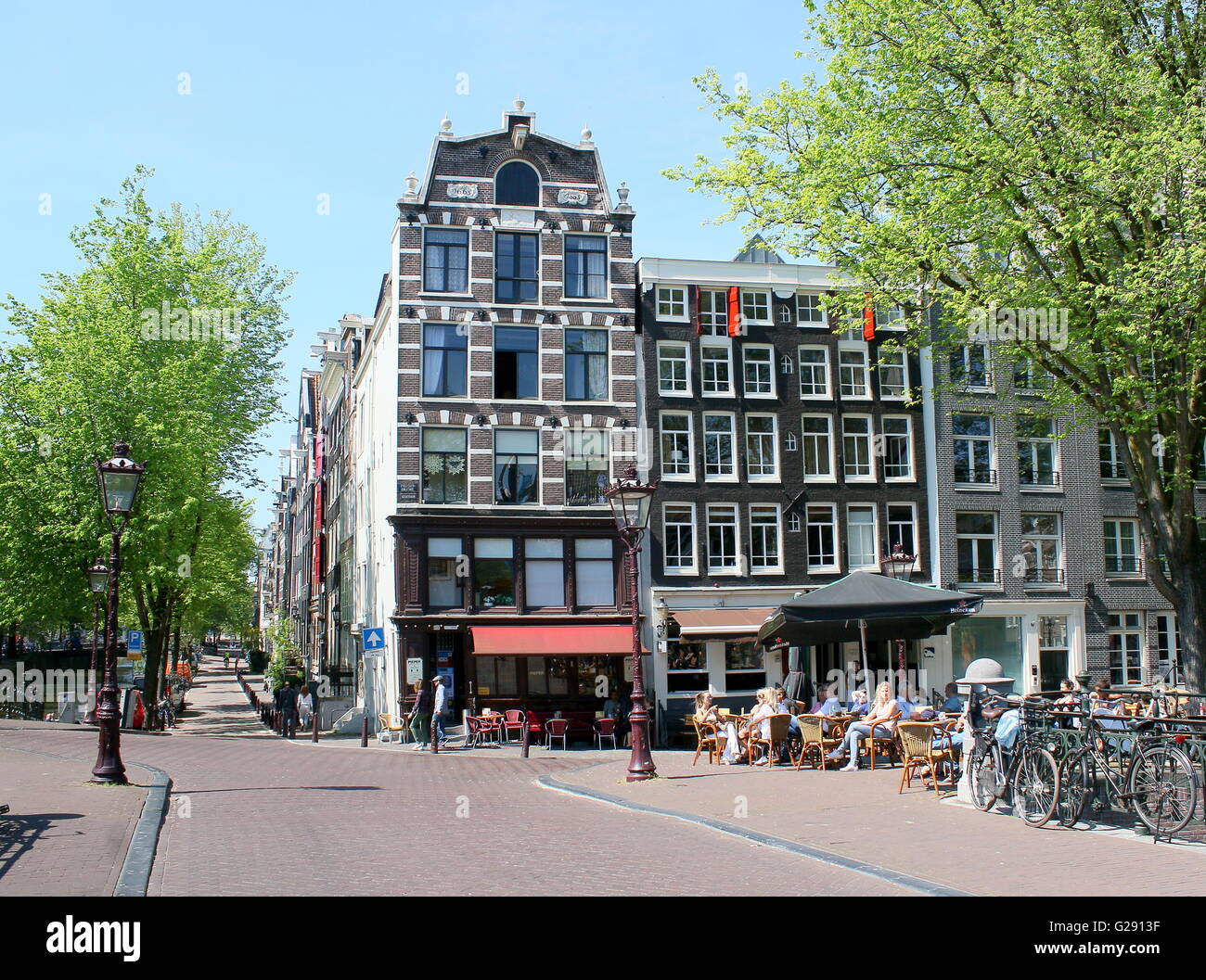 Café De Pieper (since 1665) om corner of  Prinsengracht &  Leidsegracht canal. People on terrace enjoying the spring sun. Stock Photo