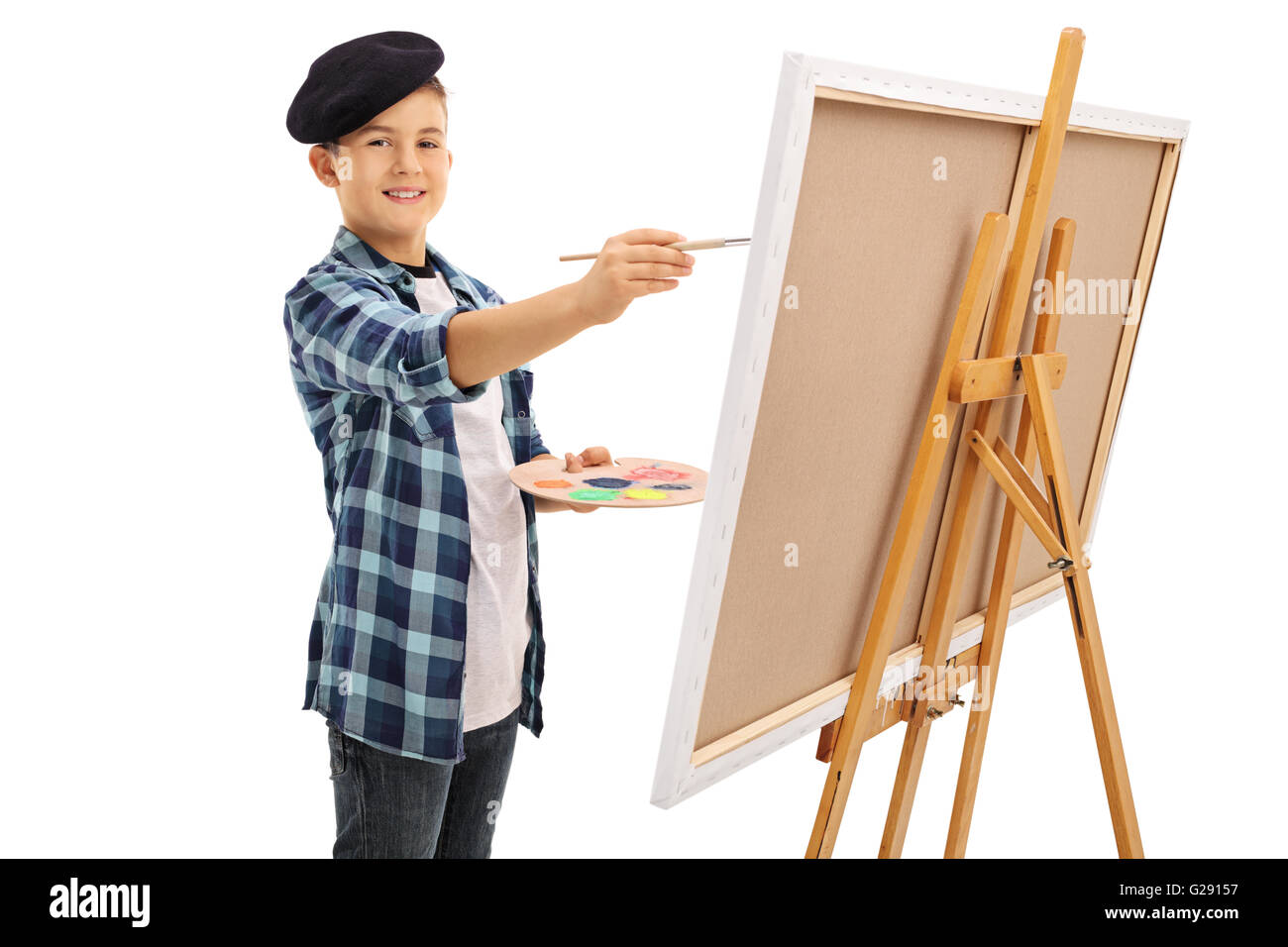 Cute little boy with a black beret painting on a canvas and looking at the camera isolated on white background Stock Photo