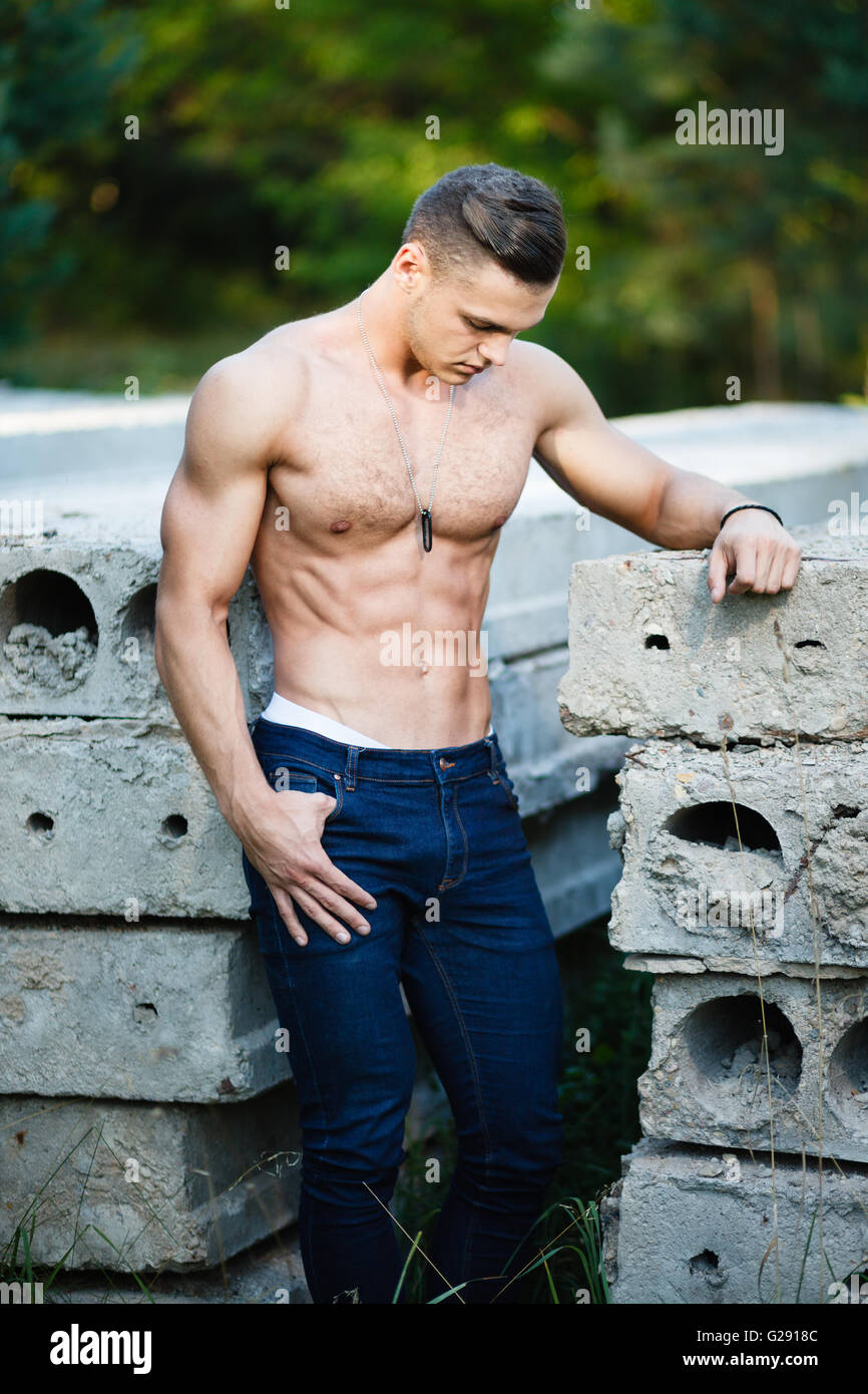 Muscular young man near concrete slab. Stock Photo