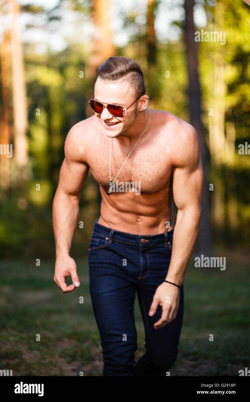 Muscular smiling young man in sunglasses. Stock Photo