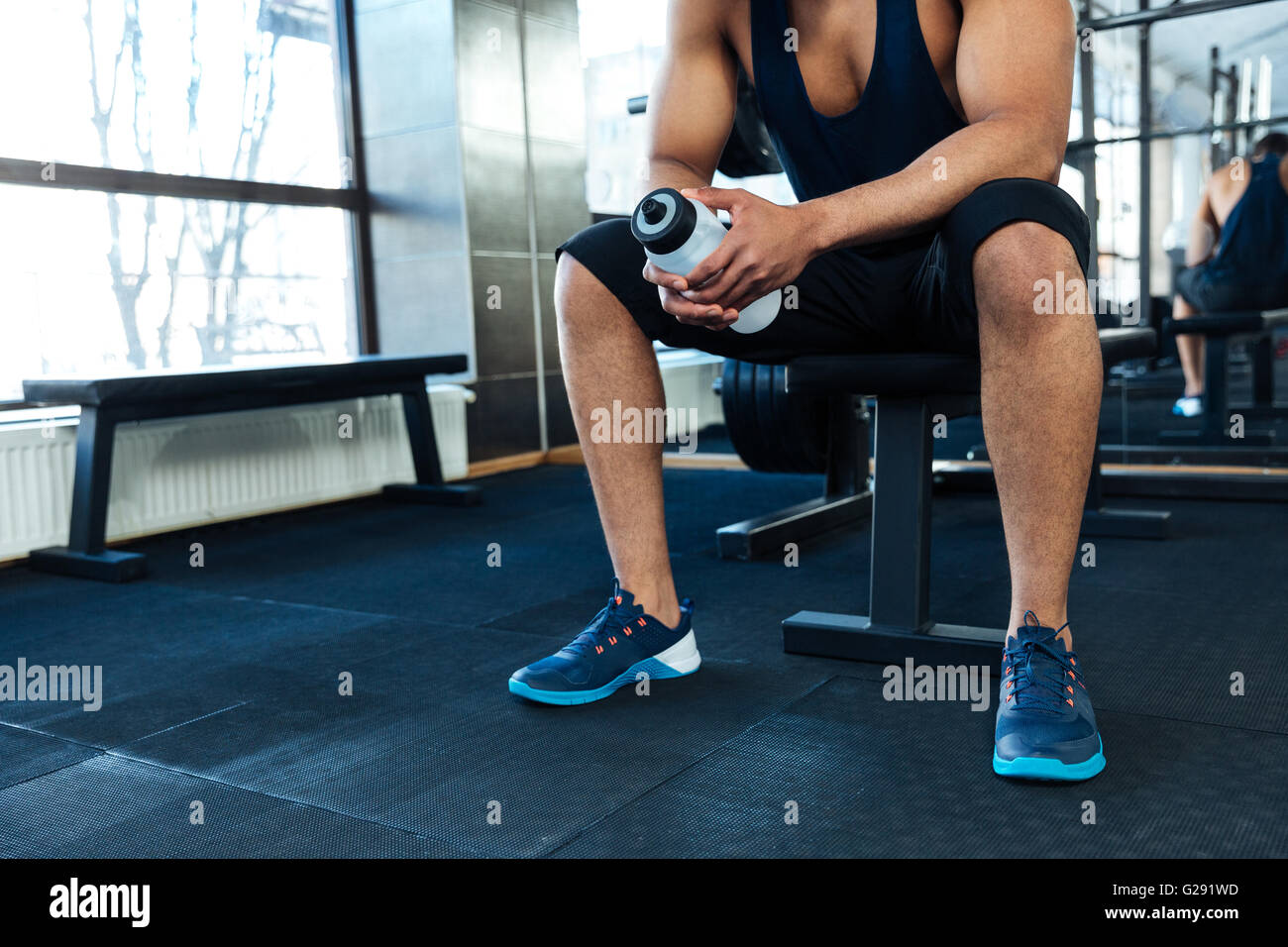 Cropped image of the man resting with a water bottle in the gym Stock ...