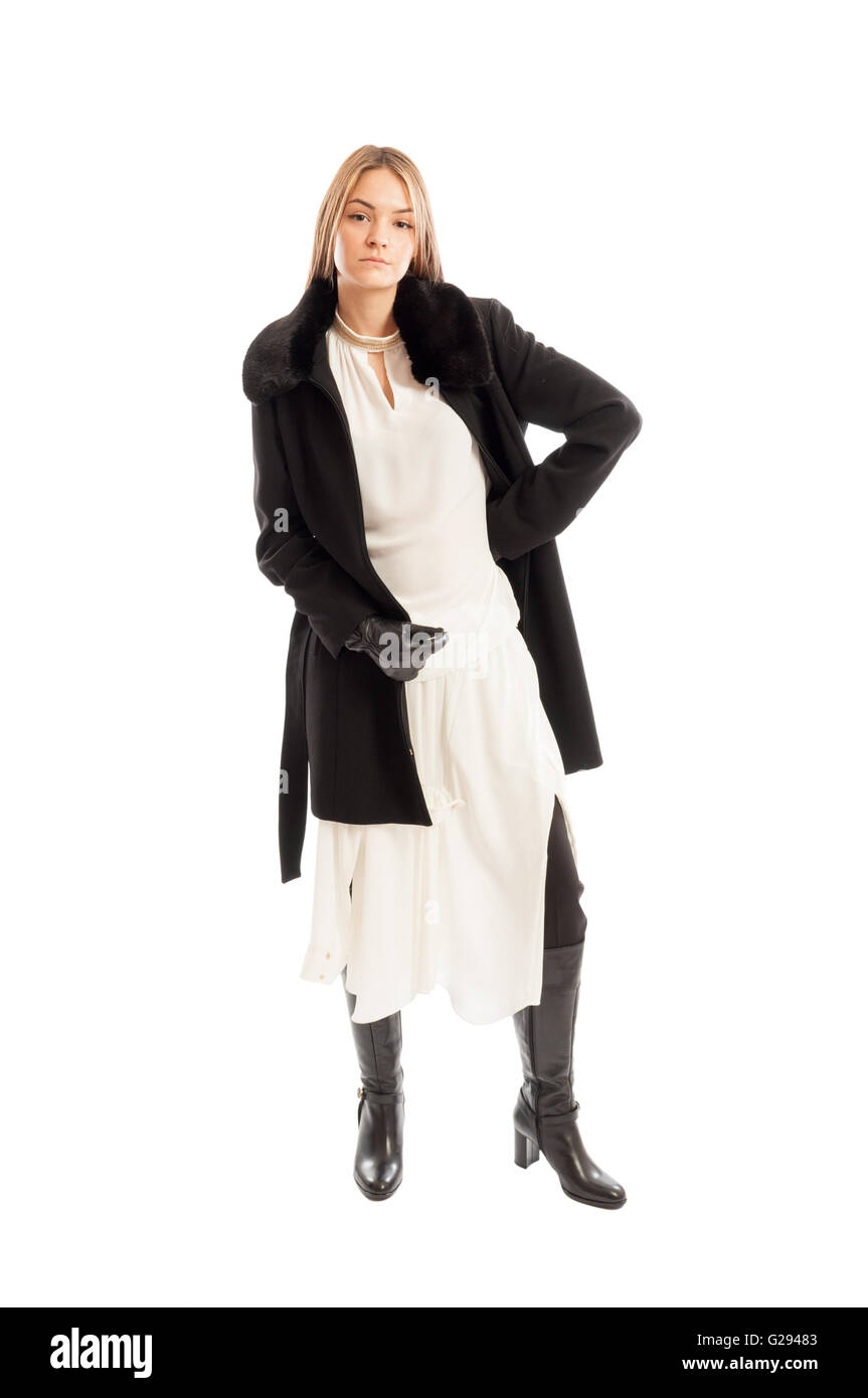 Female model wearing black wool coat on white dress and leather boots isolated on white background Stock Photo