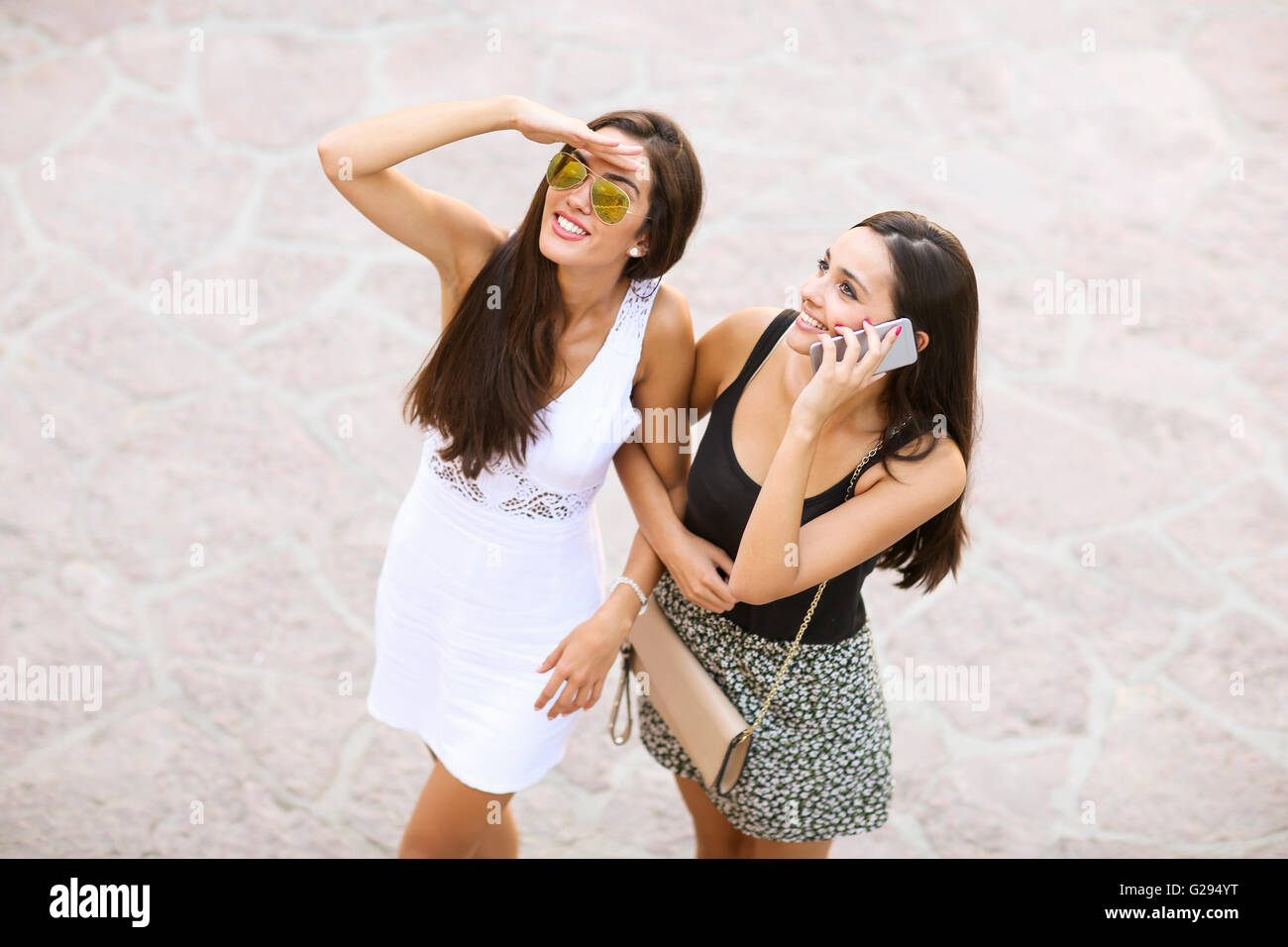 Two young women walking on the street Stock Photo - Alamy
