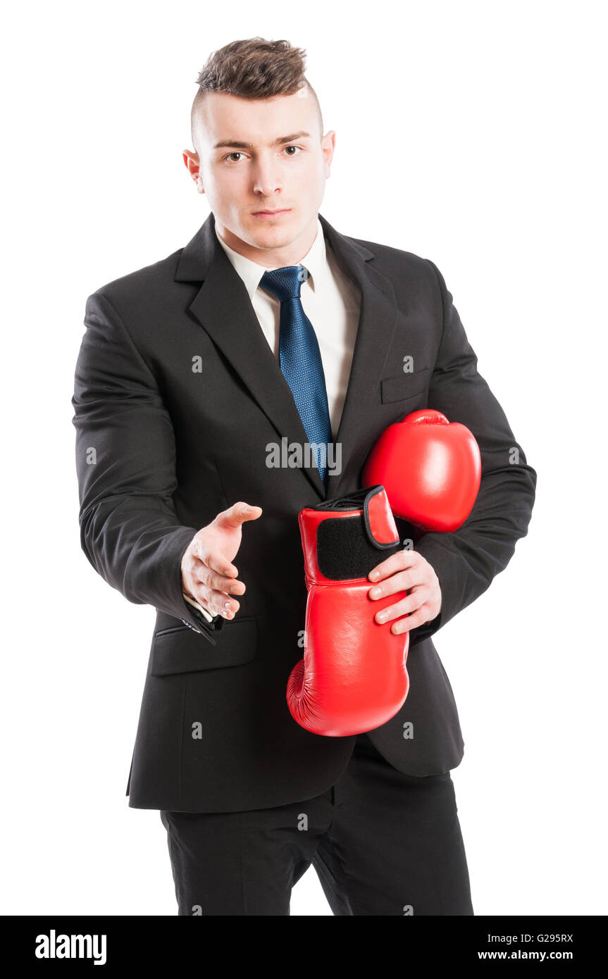 Competitive businessman giving hand for handshake while removing the boxing gloves Stock Photo