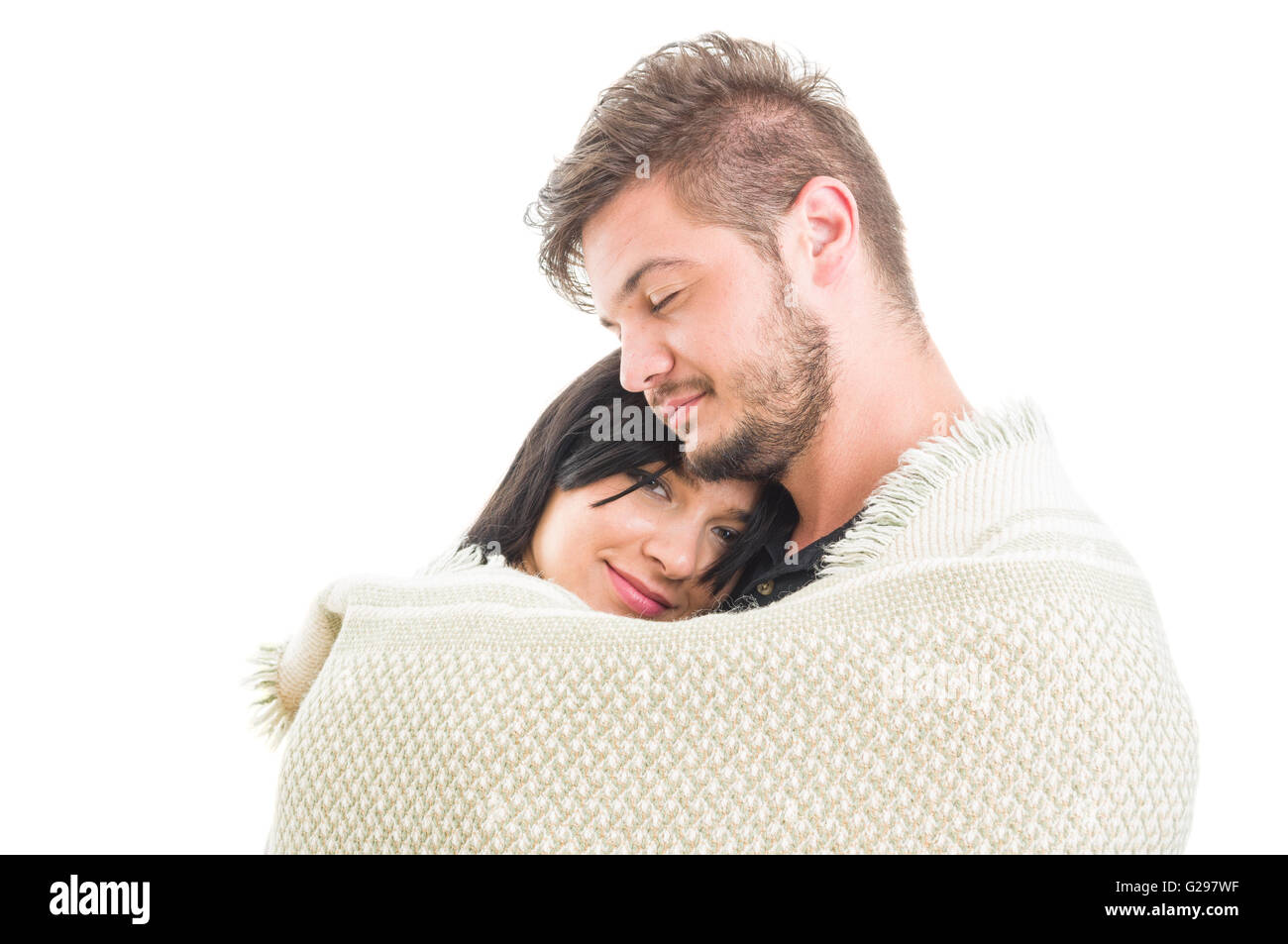 Happy young couple hugging covered with a blanket on white background
