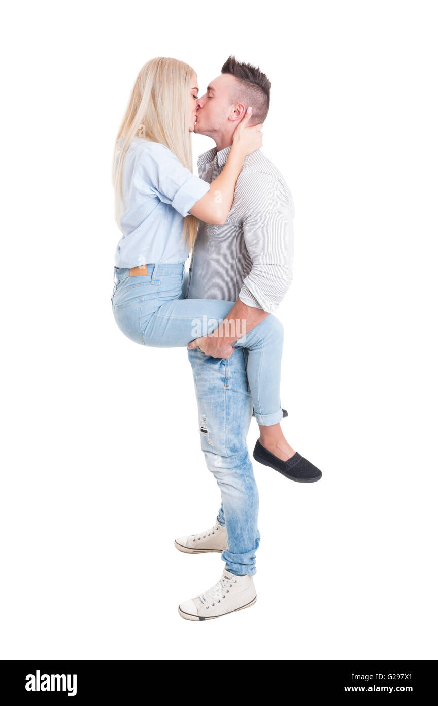 Man holding woman by legs with his strong arms. Full body couple kissing on  white background Stock Photo - Alamy