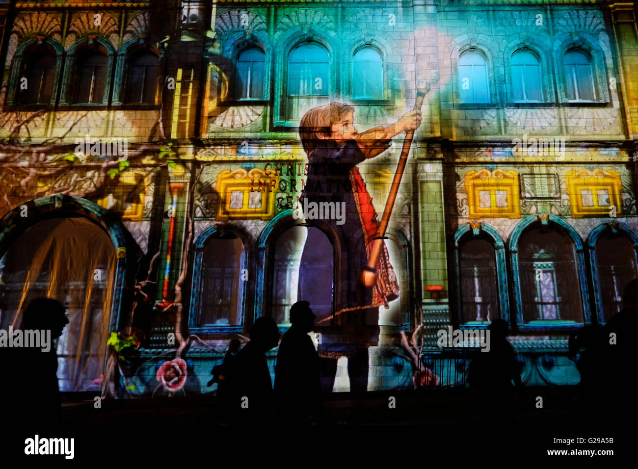 Jerusalem, Israel. 25th May, 2016. Pedestrians pass by light art projection by French artist Damien Fontaine over the building of the Christian Information Center in the old city during the Jerusalem Festival of Light in Israel which takes place annually around the old city with special effects illuminating historical sites and displays the work of leading international artists. Stock Photo