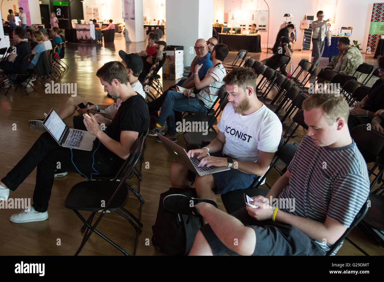 Attendees work on their laptops between presentations at Museu del Disseny, Barcelona, 26th May 2016. The first day of OFFF (Let's Feed The Future) festival in Barcelona. This design festival is now in its 16th year. PIctured: General pictures of the auditorium area and people attending the festival. Credit: Rob Watkins/Alamy Live News Stock Photo