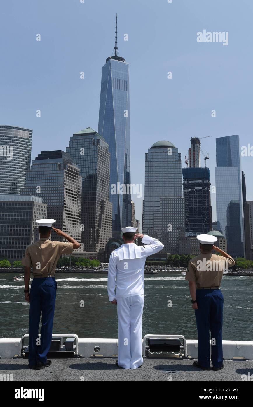 US Sailors and Marines aboard the amphibious assault ship USS Bataan man the rails to salute One World Trade Center in Manhattan as they pull into port for Fleet Week May 25, 2016 in New York City, NY. Stock Photo