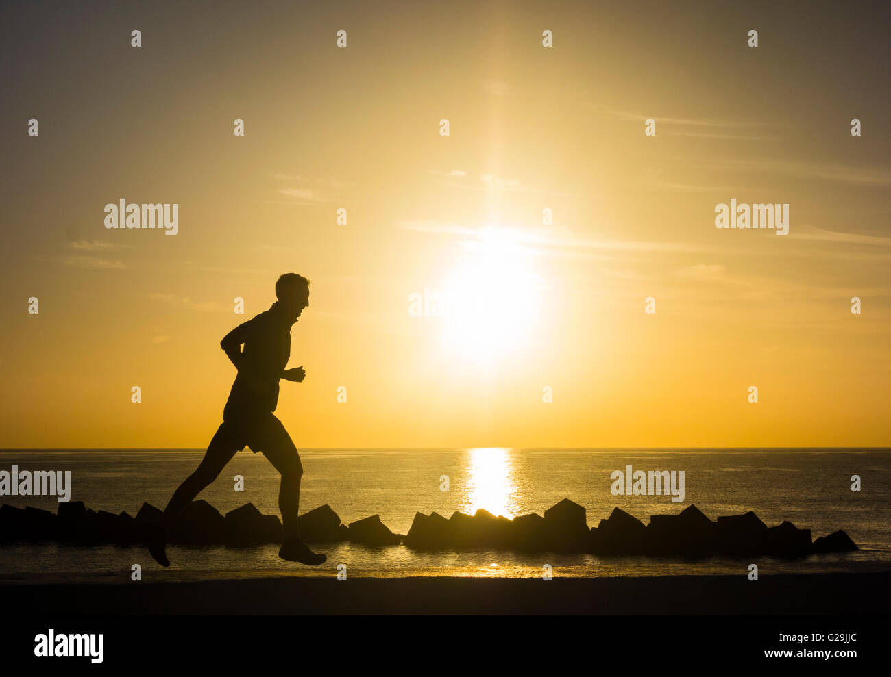 Las Palmas, Gran Canaria, Canary Islands, Spain, 27th May 2016. Weather: Jogging on sea wall as the sun rises over the Atlantic ocean on a glorious Friday morning in Las Palmas, the capital of Gran Canaria. Many will be escaping to the Canary Islands during half term, as Spain and the Canary islands are seen as a `safe` destination following terrorist the attacks in Egypt and Tunisia, according to a recent article in the UK press Credit:  Alan Dawson News/Alamy Live News Stock Photo