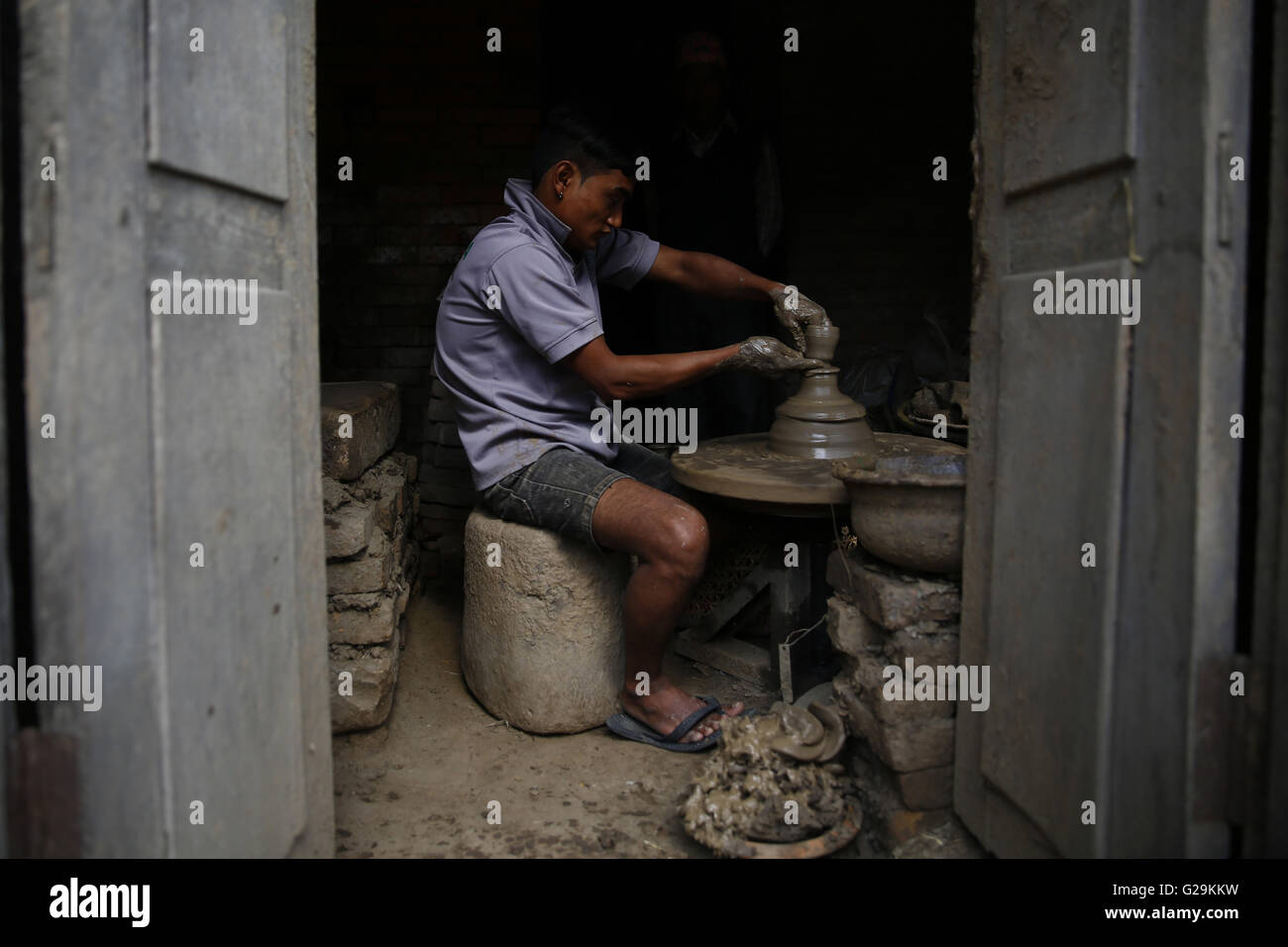 May 27, 2016 - Bhaktapur, Nepal - Dayaram Prajapati twenty-three-year-old man making clay pots using traditional methods inside his shop at the Pottery Square in Bhaktapur, Nepal on Friday, May 27, 16.  After the pots have been built it is dried for hours and later burned and taken out after four days to complete the process. This particular type of earthen is sold for Rs.8 per piece and sold throughout Nepal. Dayaram is looking after his family business, which was started for more than fifty-years. (Credit Image: © Skanda Gautam via ZUMA Wire) Stock Photo