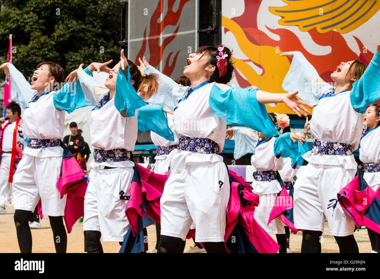 Women team in white and turquoise happi jackets, dancing outdoors, in rows, during the Hinokuni Yosakoi dance festival in Kumamoto, Japan. Stock Photo