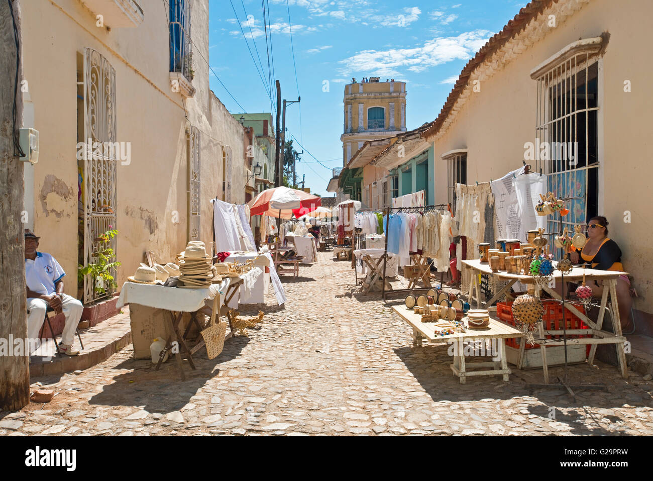 Typical colourful street road market scene near the center of Trinidad in Cuba with local people selling tourist items. Stock Photo