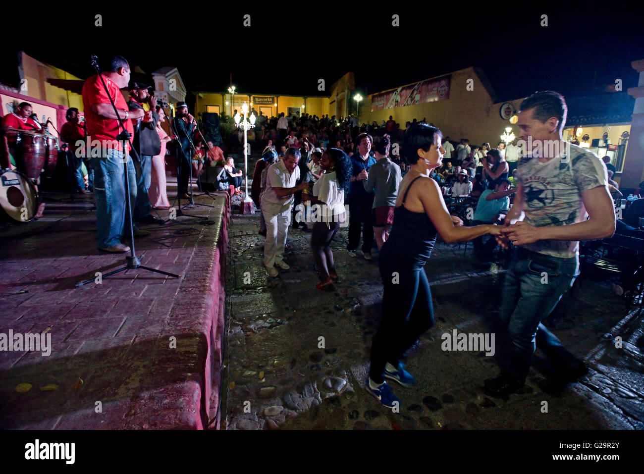 Cuban musicians in a group playing and singing salsa for locals and tourists at the Casa de la Músíca in Trinidad, Cuba. Stock Photo
