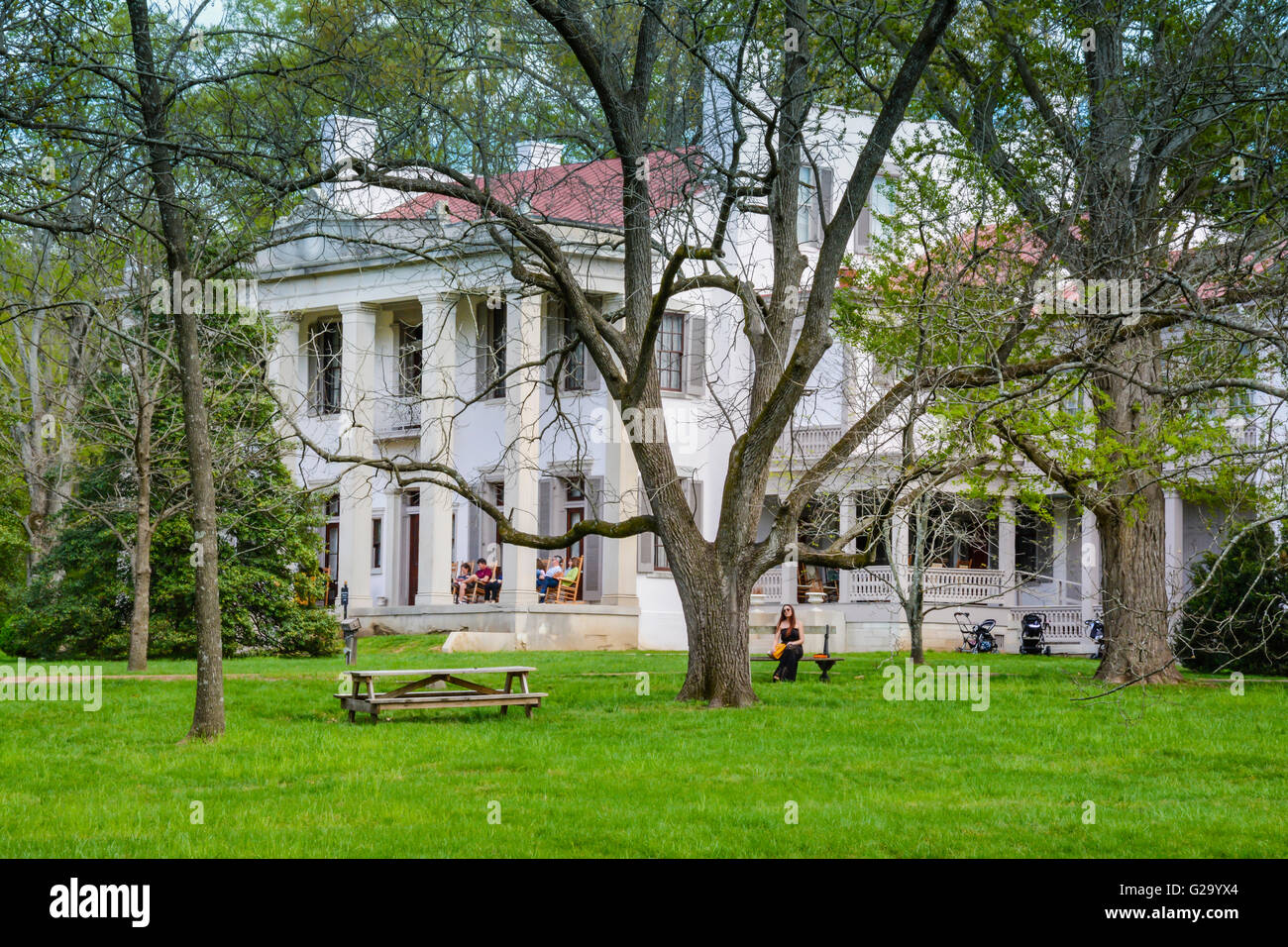 Tourists enjoy the veranda and tree covered grounds of The Belle Meade Plantation Mansion in Spring time in Nashville TN Stock Photo