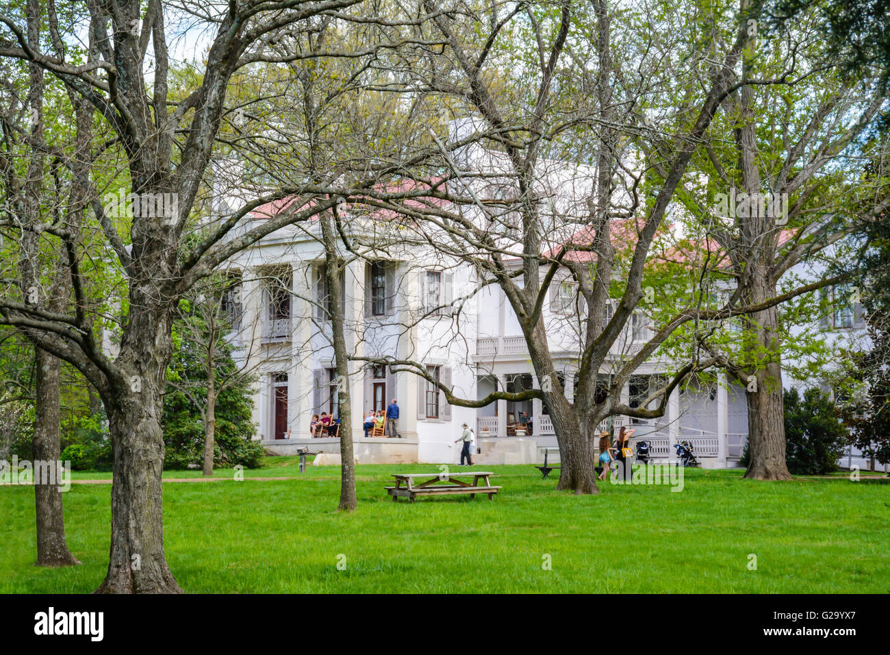 Visitors enjoy the veranda and tree covered grounds of The Belle Meade Plantation Mansion in Spring time near Nashville, TN Stock Photo