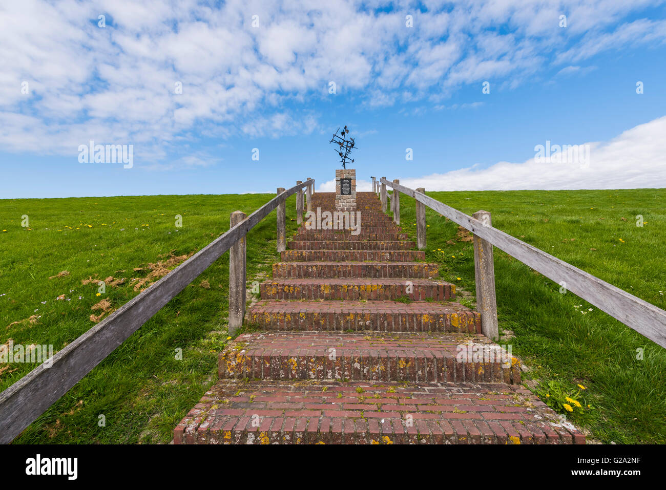 Statue for the dead fishermen on the Waddensea dike with stone stairs at Wierum in Friesland Stock Photo