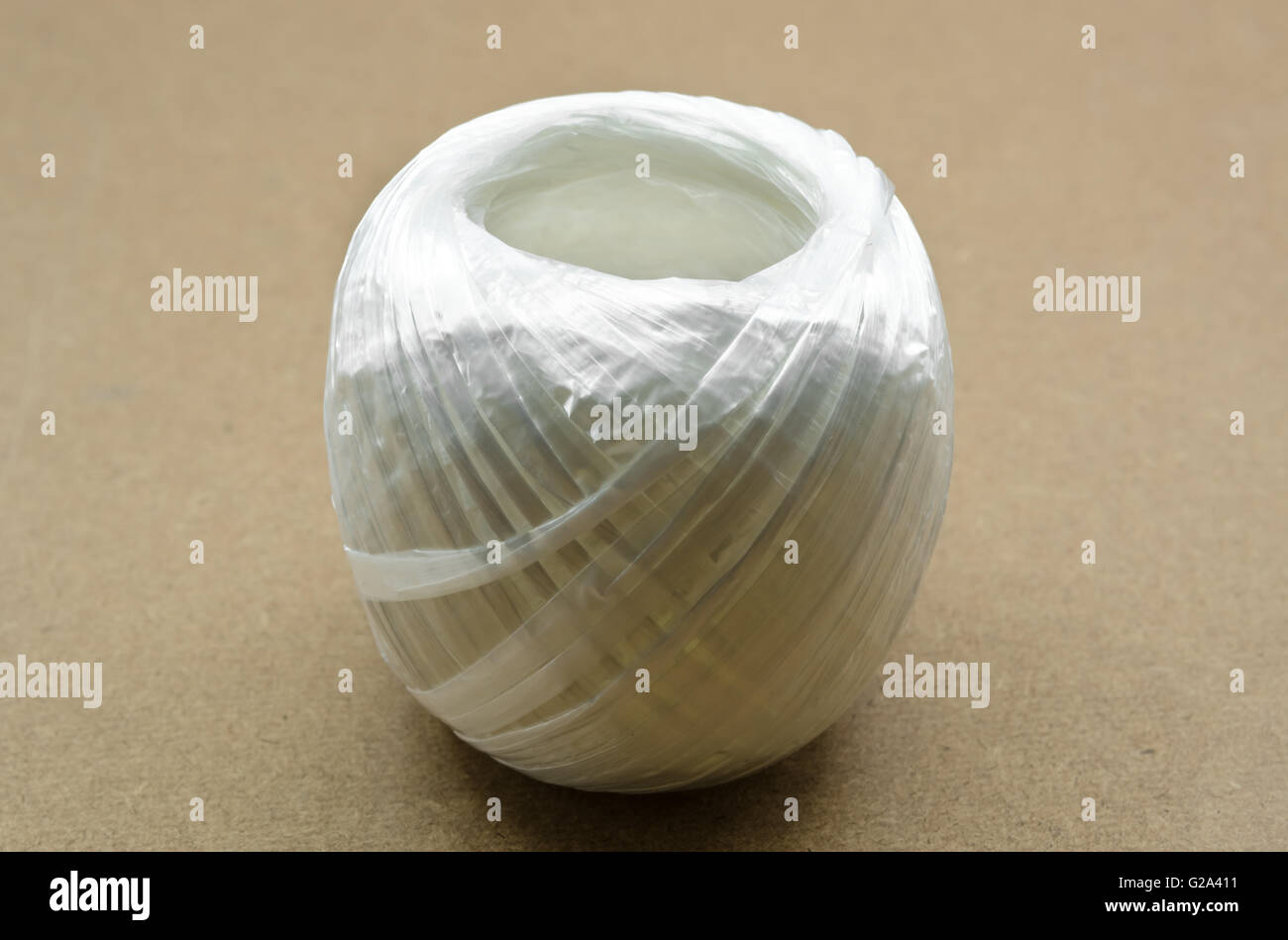 Coil of white plastic rope on brown background Stock Photo - Alamy