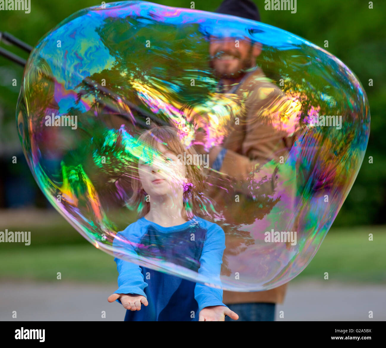 Boy Catching Large Soap Bubble Outdoors Stock Photo