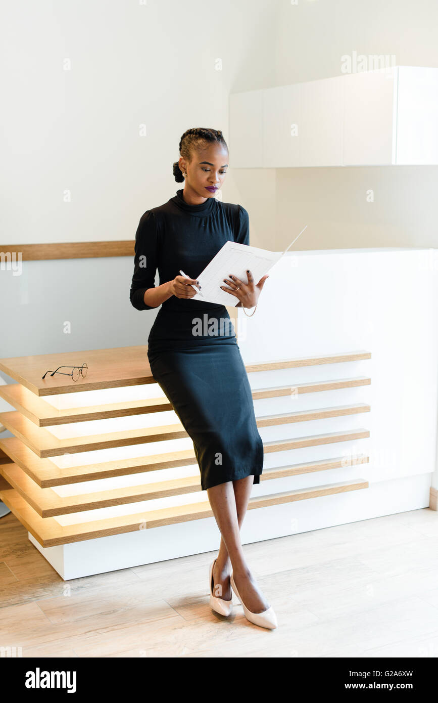 Stern elegant business woman wearing black dress and beige shoes in light office looking at her agenda, full length portrait Stock Photo - Alamy Stern elegant business woman wearing black dress and beige shoes in light office looking at her agenda, full length portrait Stock Photo - Alamy