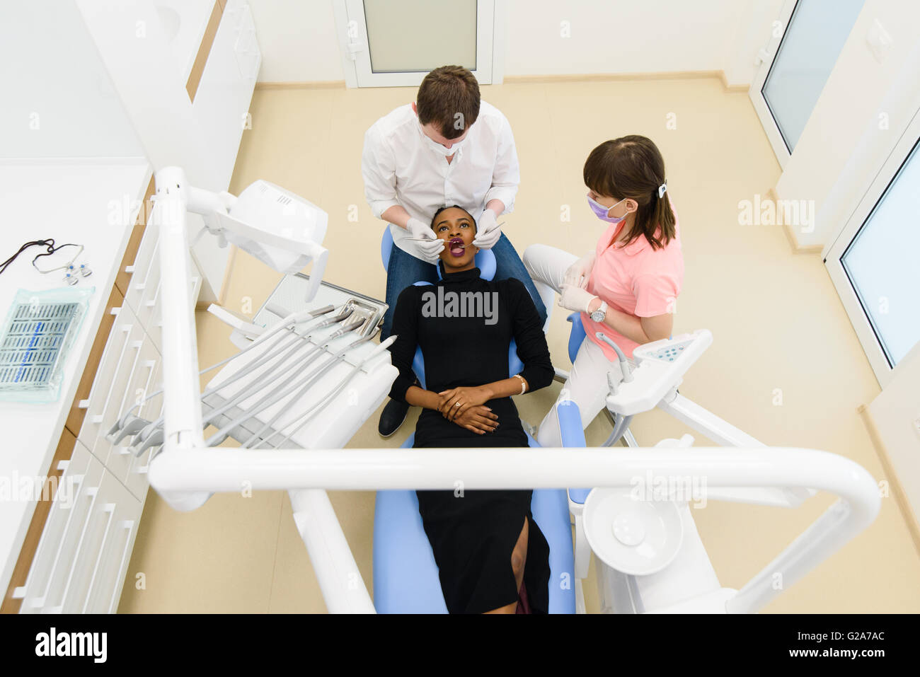 Top view of Black American or African female patient with dentist, assistant in a dental