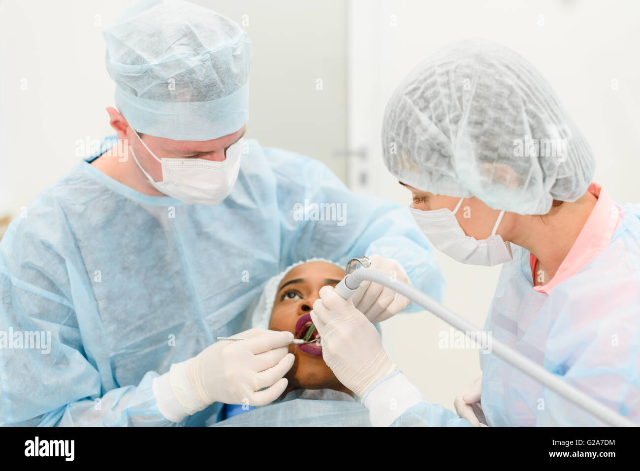 Dentist with assistant wearing uniforms making medical procedures