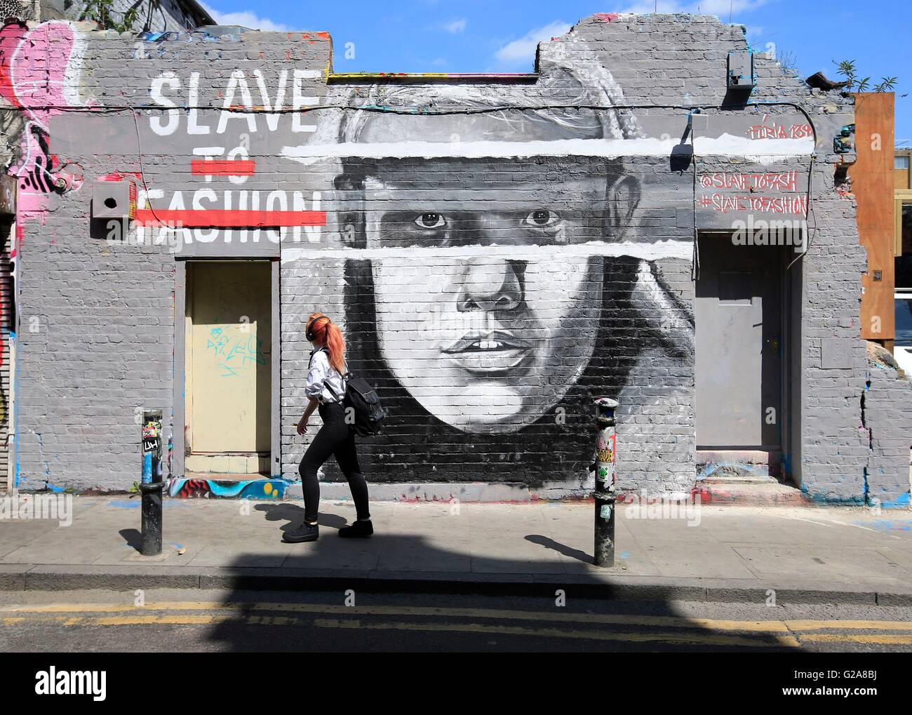 A pedestrian looks at a mural painted in Hackney Street, London. Stock Photo