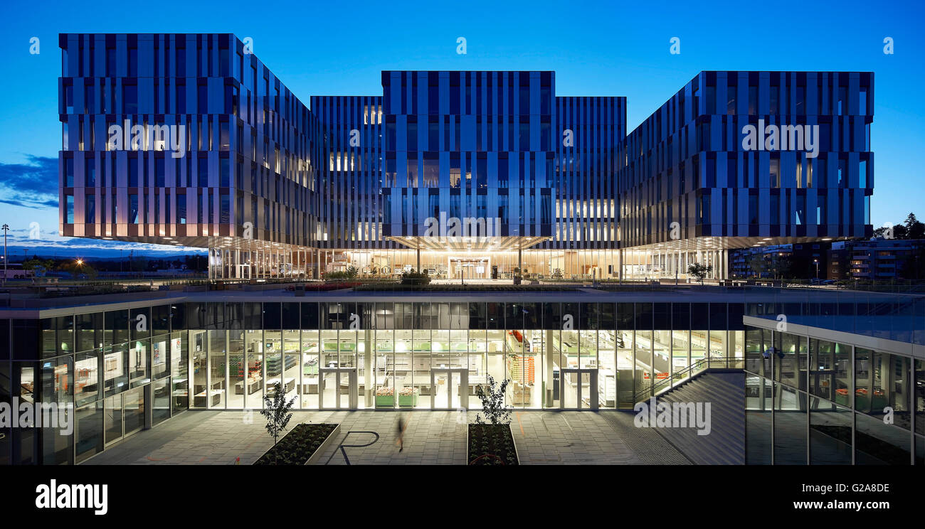 Front elevation with floating volumes and lowered atrium at night. Fornebuporten, Oslo, Norway. Architect: DARK, 2015. Stock Photo