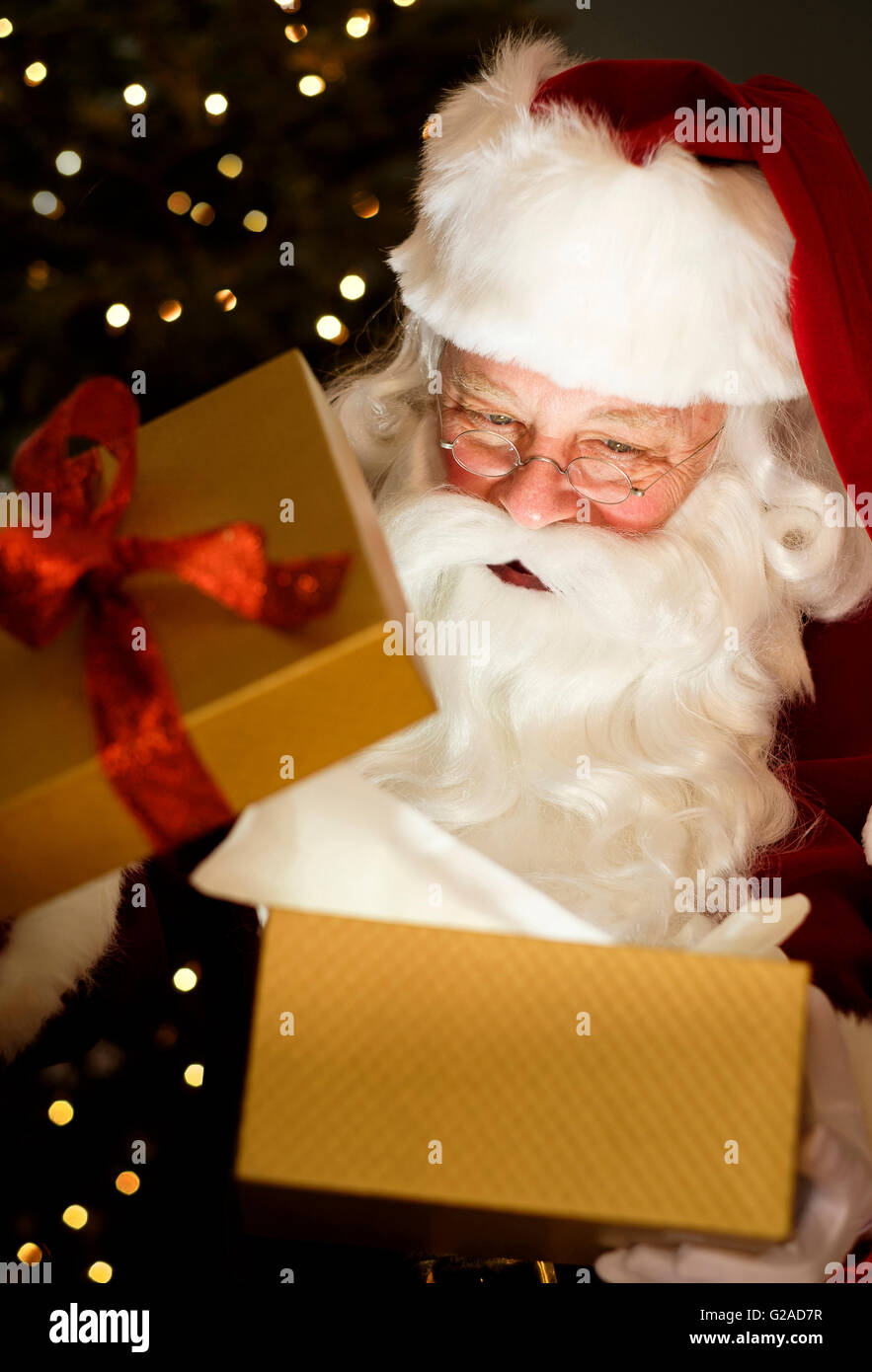 Portrait of Santa Claus opening Christmas presents Stock Photo