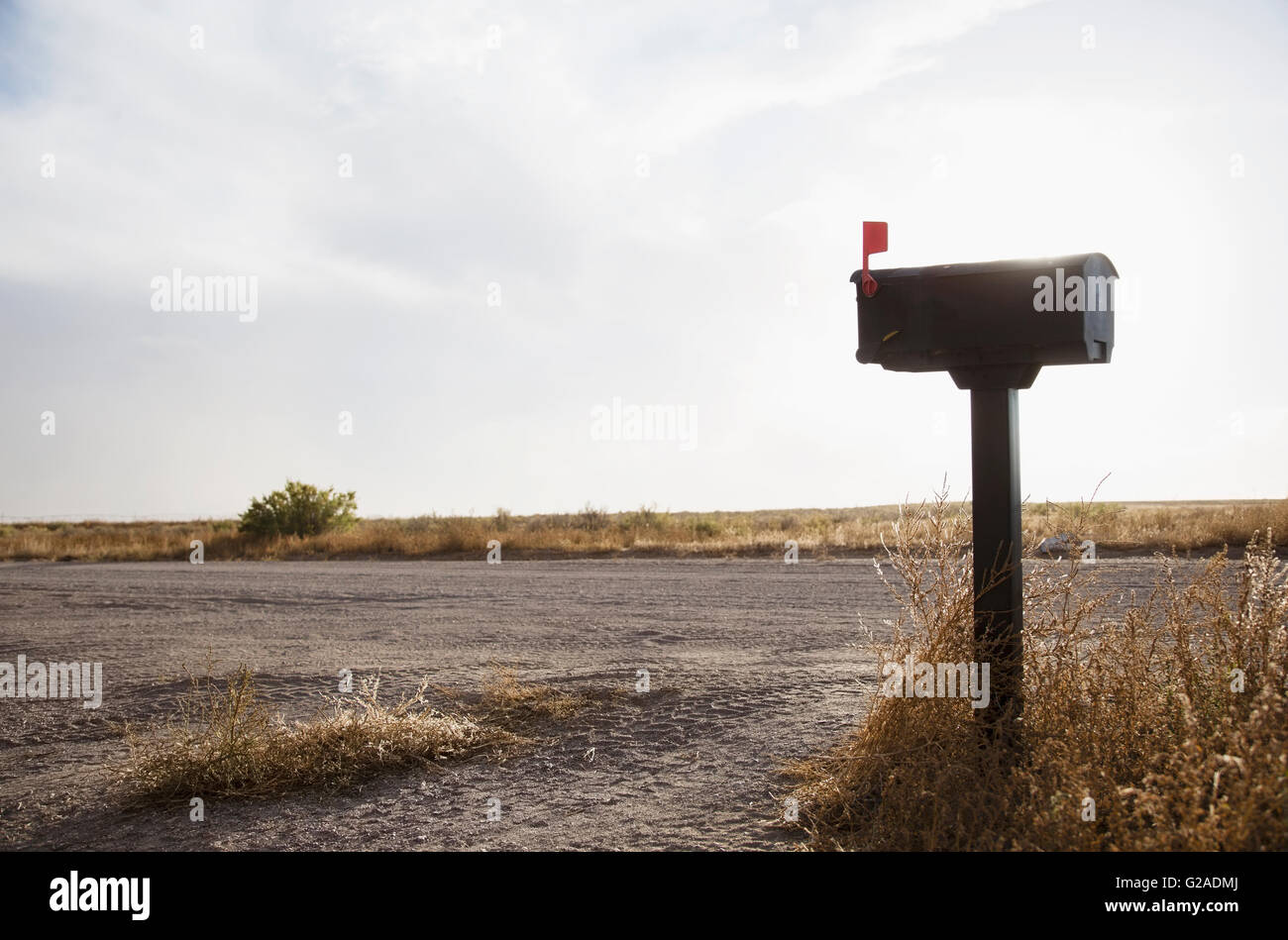 Mailbox by empty dirt road Stock Photo