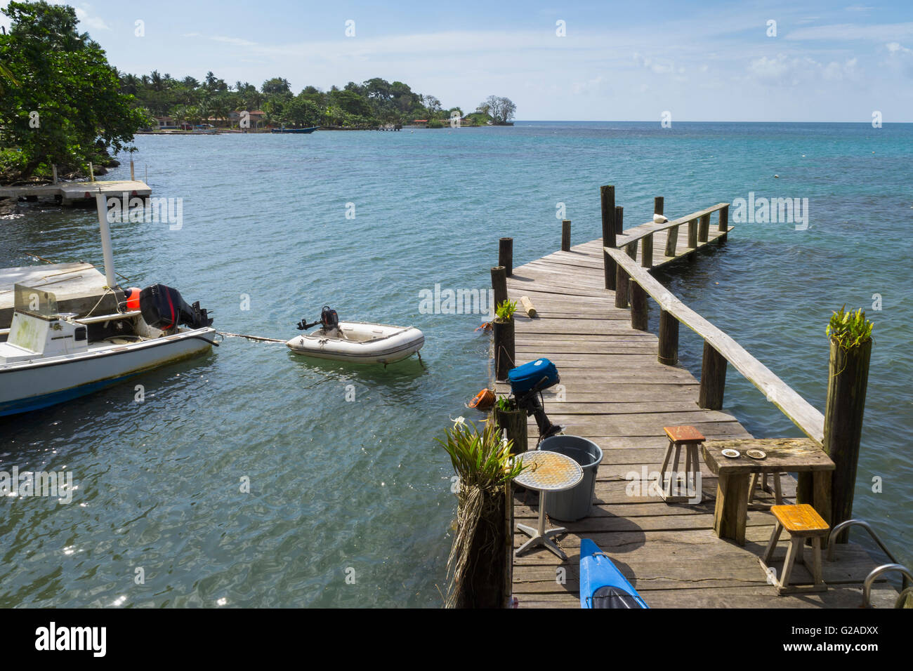 Wooden jetty with motor boat nearby on sea Stock Photo