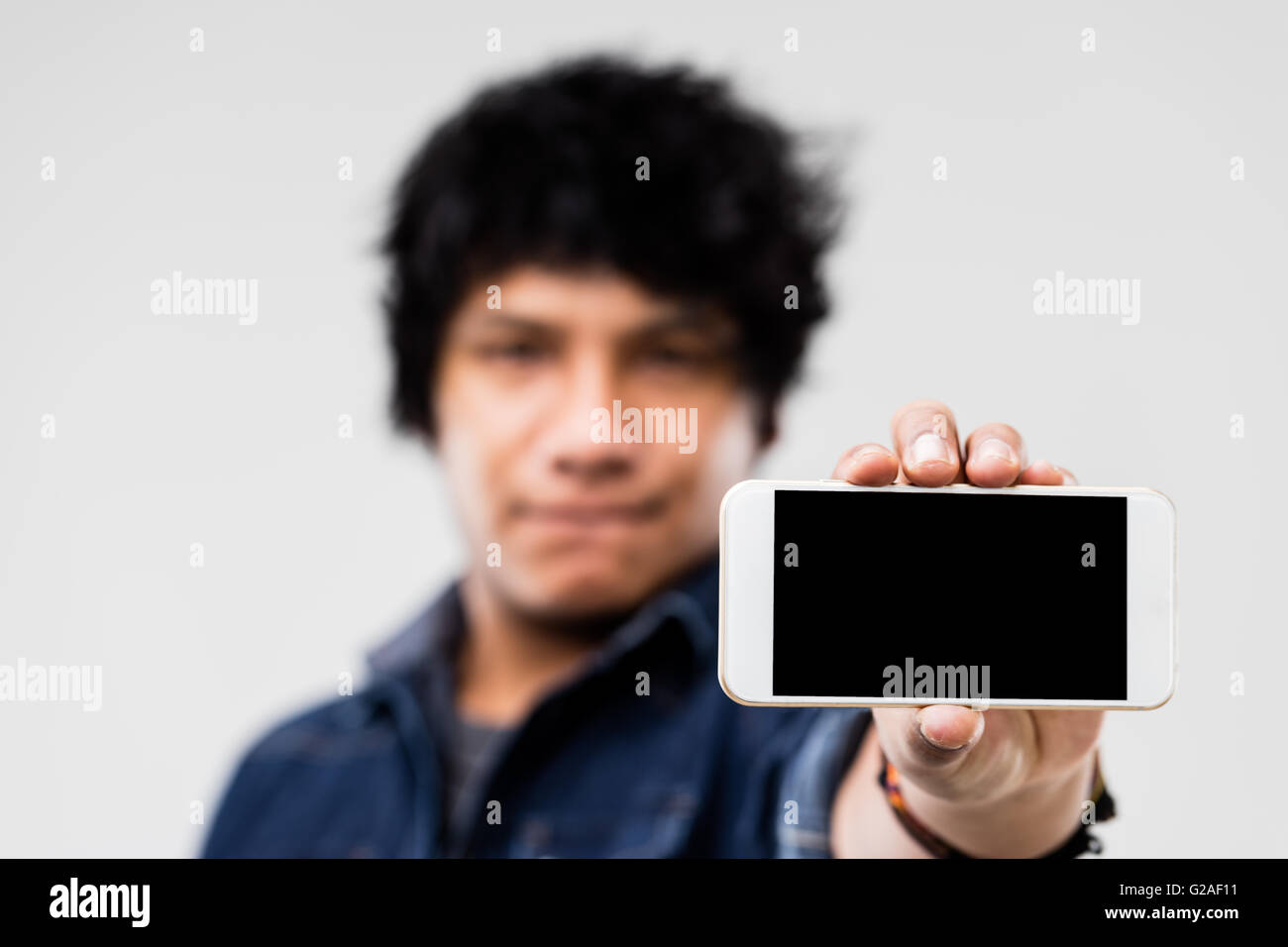 blank screen of a smartphone (copyspace) shown to you by a robust mulatto guy Stock Photo