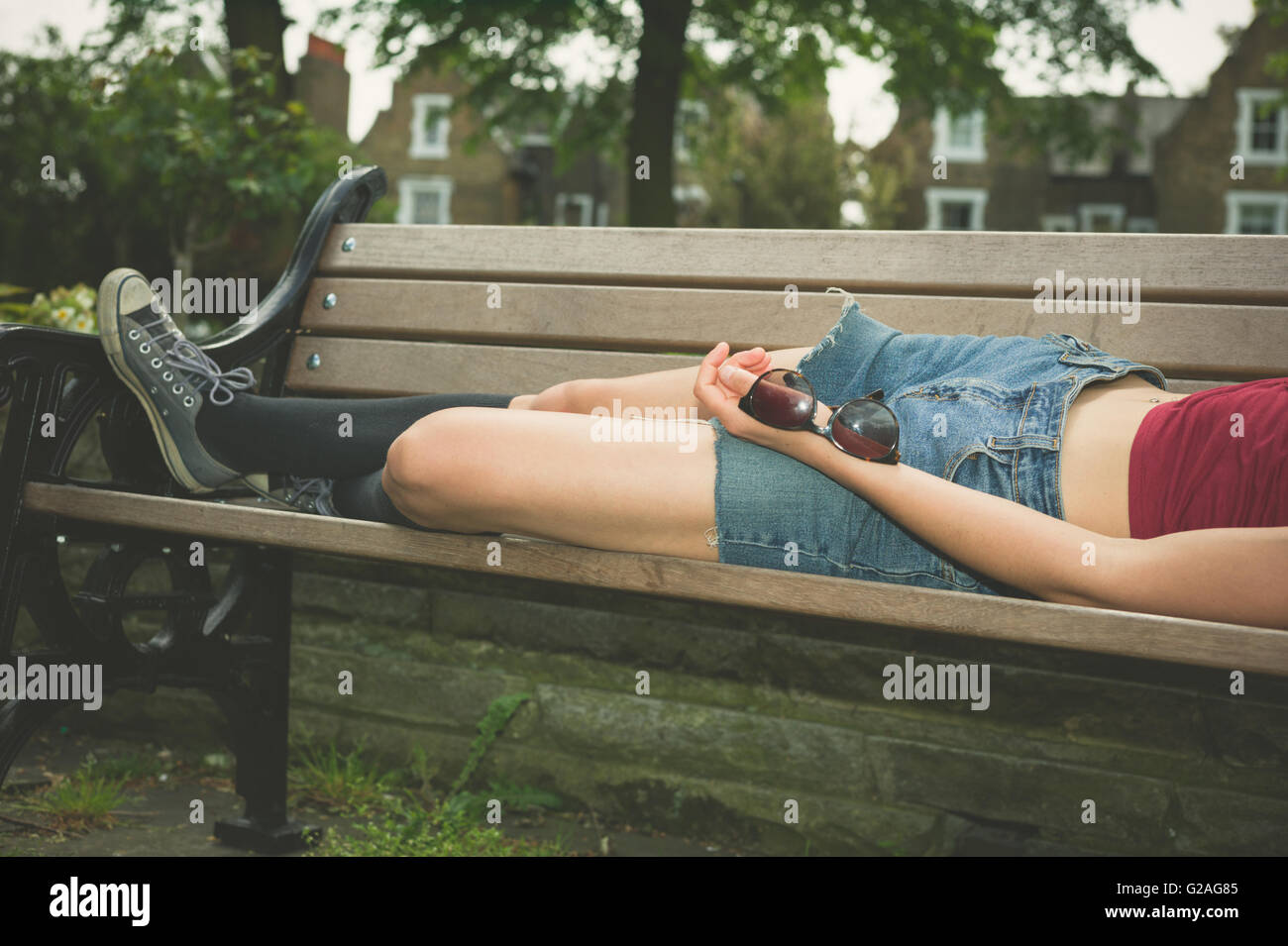 Woman sleeping on park bench hi-res stock photography and images - Alamy