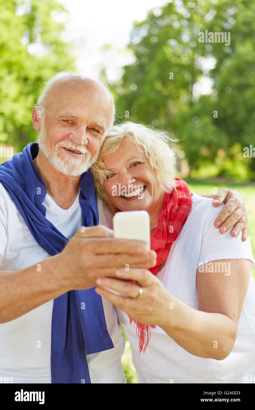 Happy senior couple taking selfie with smartphone in nature Stock Photo ...