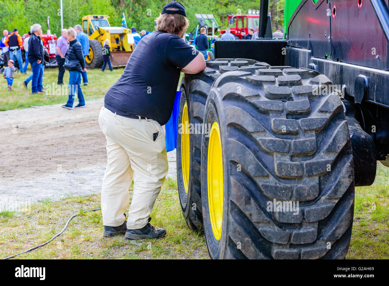 Emmaboda, Sweden - May 14, 2016: Forest and tractor (Skog och traktor) fair. Large person leaning against some large forwarder o Stock Photo