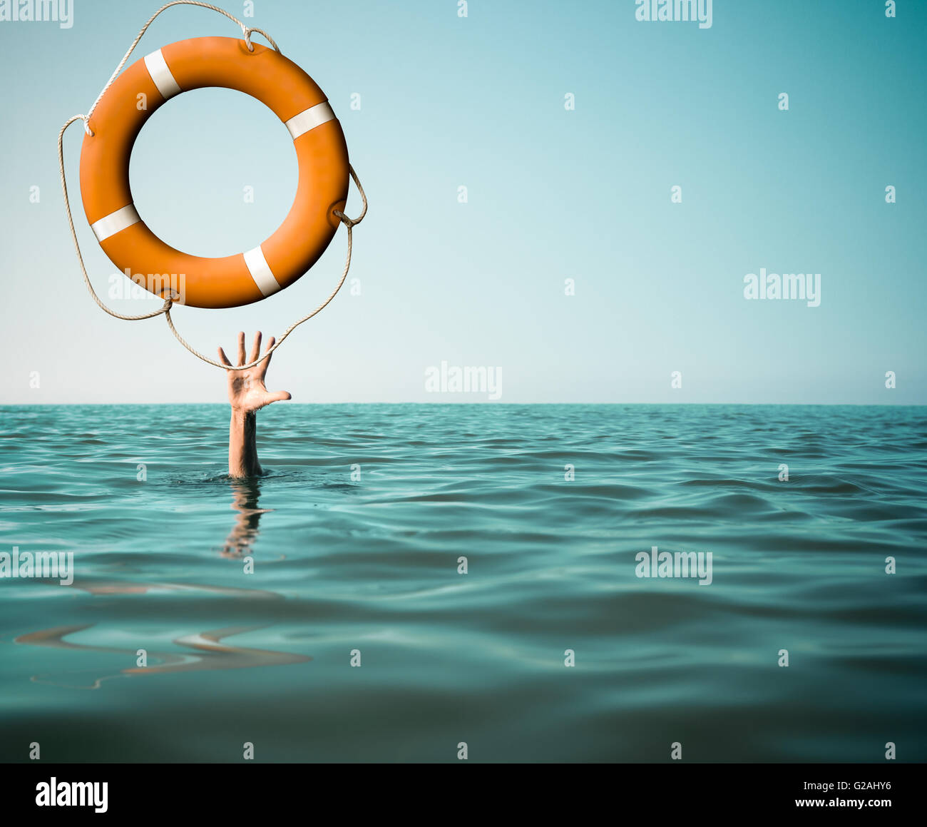 Drown man with rised hand getting lifebuoy help in sea Stock Photo