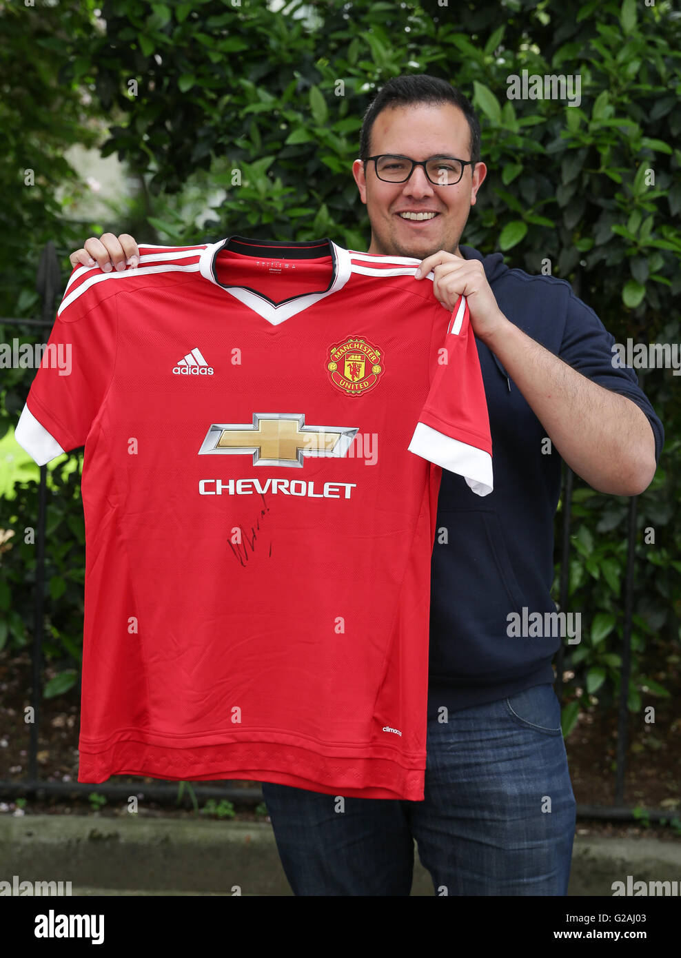 Steven Ribeiro Steven Ribeiro poses with the first Manchester United shirt to be ...