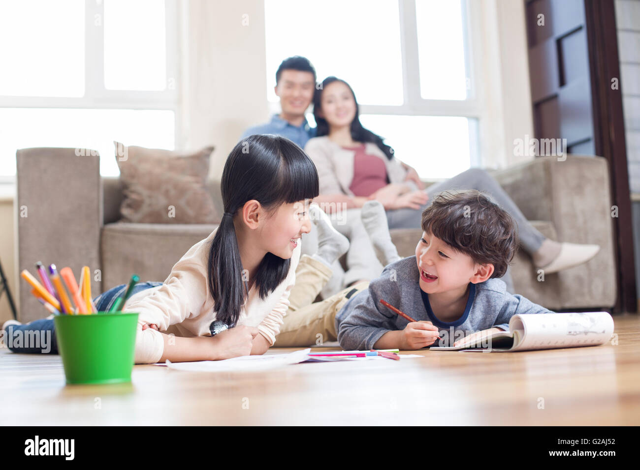 Happy siblings studying together at home Stock Photo - Alamy