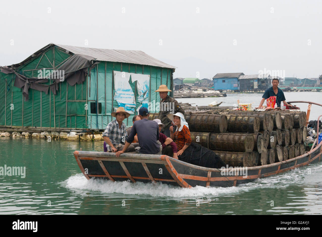 Fishing boat carrying shrimp cages and floating village along the coast of East China Sea, Xiapu, Fujian Province, China Stock Photo