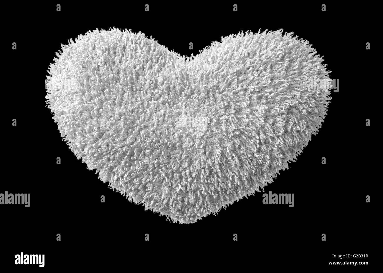 A isolated white plush  heart on black background Stock Photo