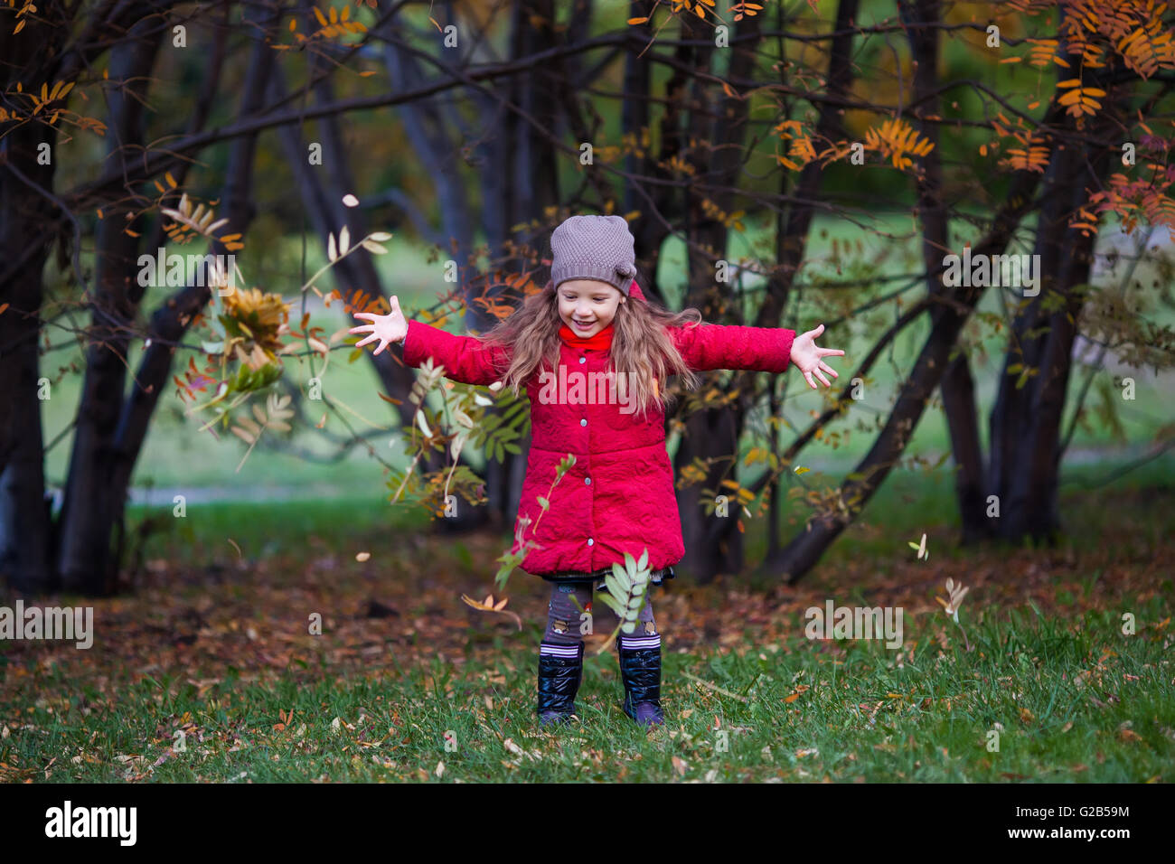 Little girl with leaves in autumn park Stock Photo - Alamy