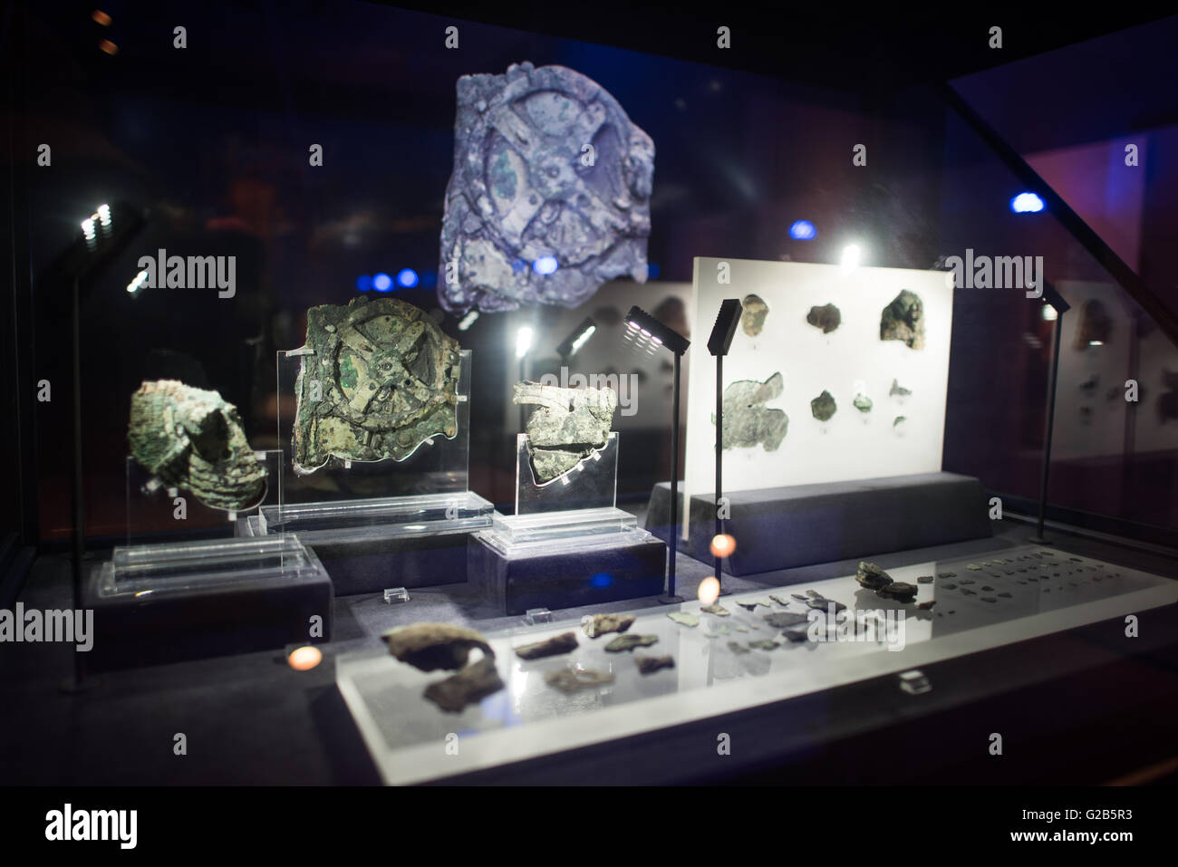 Antikythera Mechanism Fragments National Archaeological Museum Athens Greece // ATHENS, Greece — Original fragments of the Antikythera Mechanism on display at the National Archaeological Museum in Athens, Greece. The ancient Greek astronomical calculator, discovered in a shipwreck in 1900, dates to between 100 BC and 205 BC. The corroded bronze fragments represent the world's oldest known complex astronomical computing device. Stock Photo