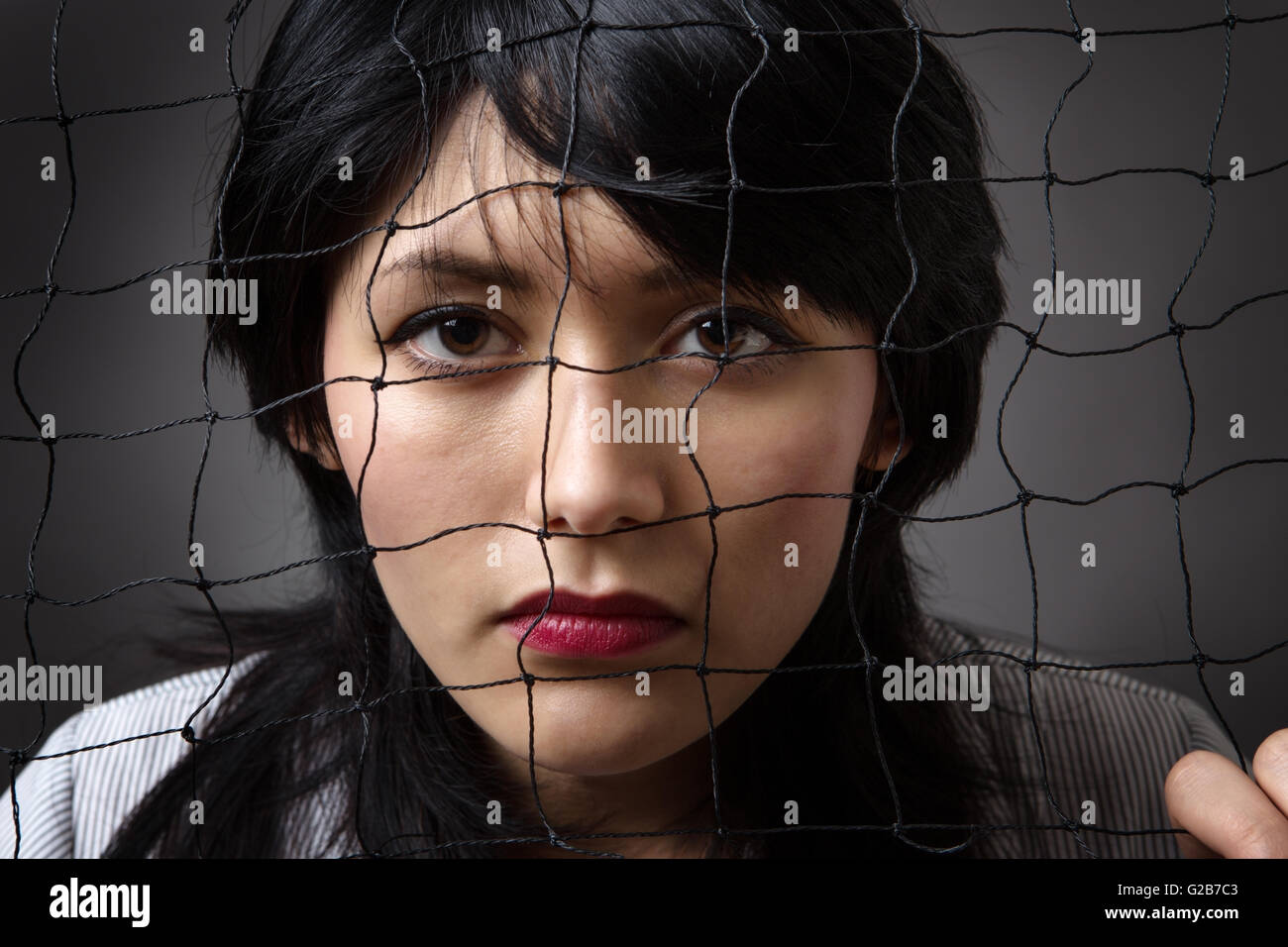 Studio shot of a business woman behind a  net Stock Photo