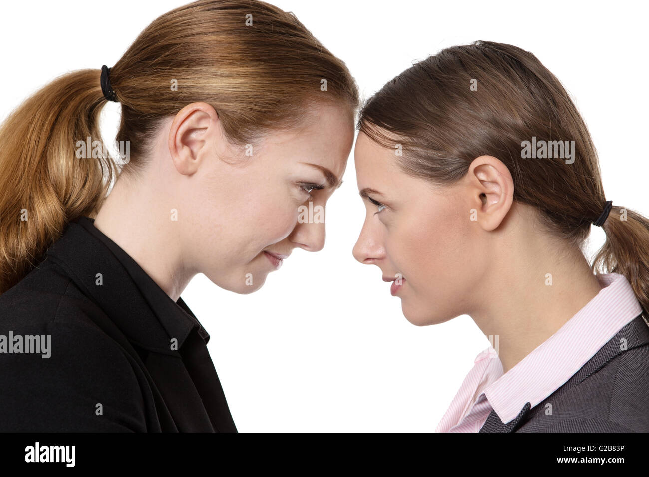 Close up office shot of two businesswomen knocking their heads together.  isolated on white Stock Photo