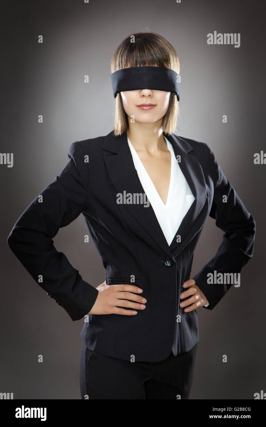 blind folded business woman low key lighting shot in the studio on a gray background Stock Photo