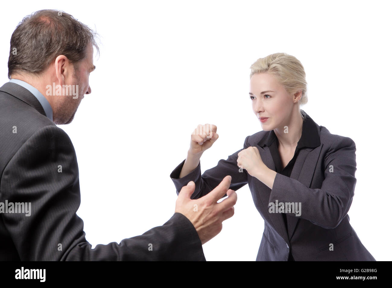 Studio shot of two co-workers wearing suits, fighting in the office, isolated on a white background. Stock Photo